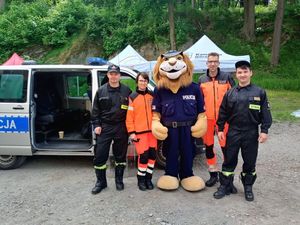 Policjanci umundurowani wraz ratownikami medycznymi.