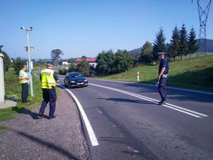 Umundurowany strażnik ochrony kolei i policjant ruchu drogowego w trakcie zatrzymywania pojazdu