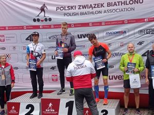 Mężczyźni stojący na podium, którym wręczane są nagrody