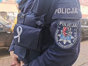 Policjant, który na mundurze przyczepioną ma białą wstążkę