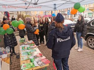 Umundurowana policjantka przy stoisku, przed nią grupa osób