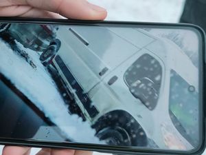 Zdjęcie ekranu telefonu, na którym widać białego busa