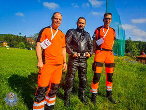 dwóch ratowników medycznych razem z policjantem na boisku