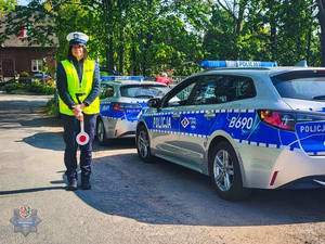 Policjantka trzymająca w ręku tarcze do zatrzymania pojazdów