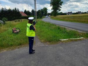 Policjantka na poboczu, która mierzy prędkość