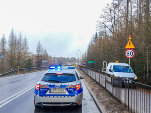 Radiowóz na drodze przez znakiem ograniczającym prędkość