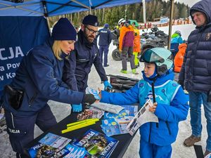 Policjanci przekazują dzieciom odblaski i ulotki