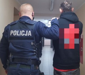 Policjant z Komendy Powiatowej Policji w Kamiennej Górze prowadzący zatrzymanego za posiadanie marihuany mężczyznę